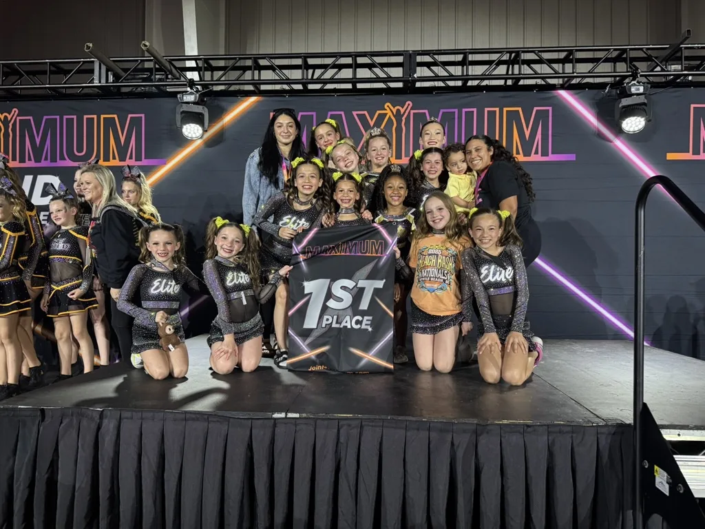 Elite Cheer team celebrating a 1st place win on stage at a national competition