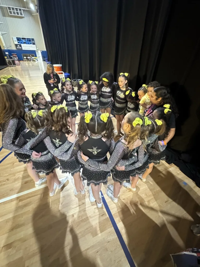 Elite Cheer athletes in a team huddle before taking the competition floor