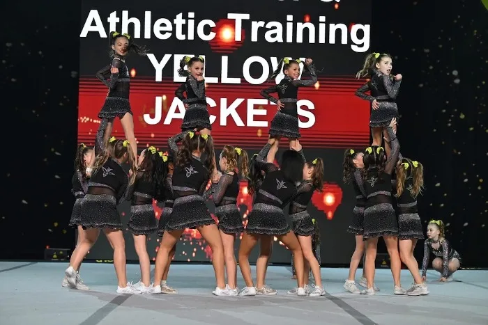 Elite Cheer Yellow Jackets team in a stunt formation at a competition